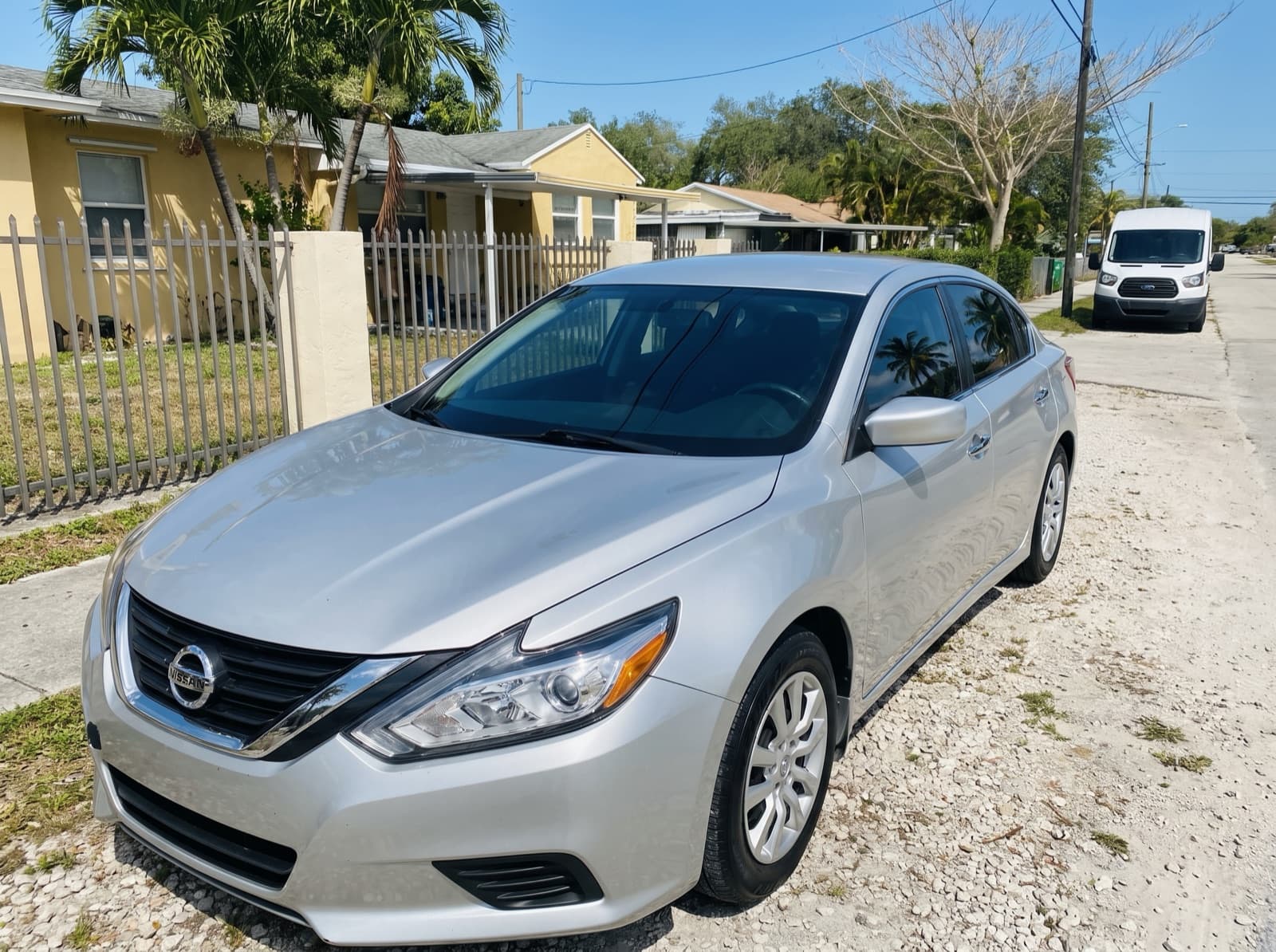 A silver sedan on a residential street in Miami, FL, after a Bang AutoGlass mobile glass job